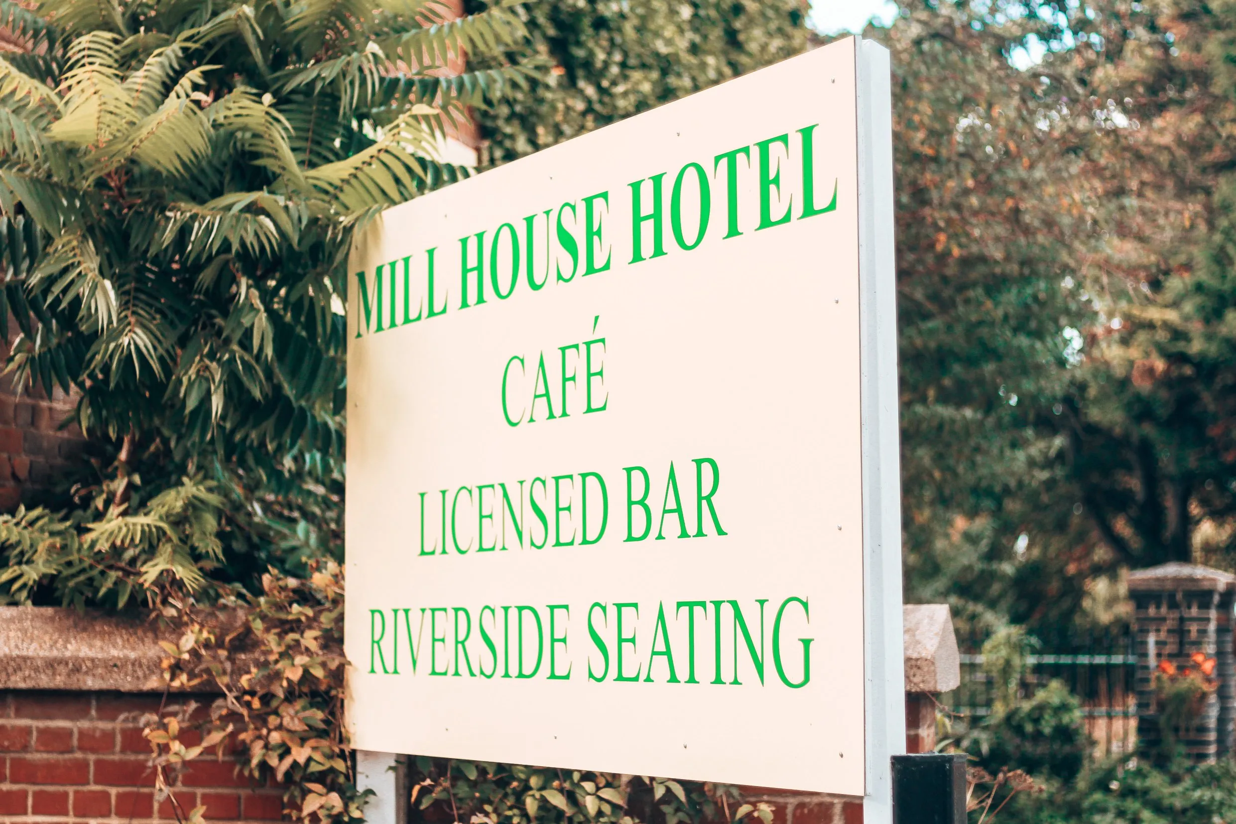 The hotel sign: Mill House Hotel, café, licensed bar, riverside seating