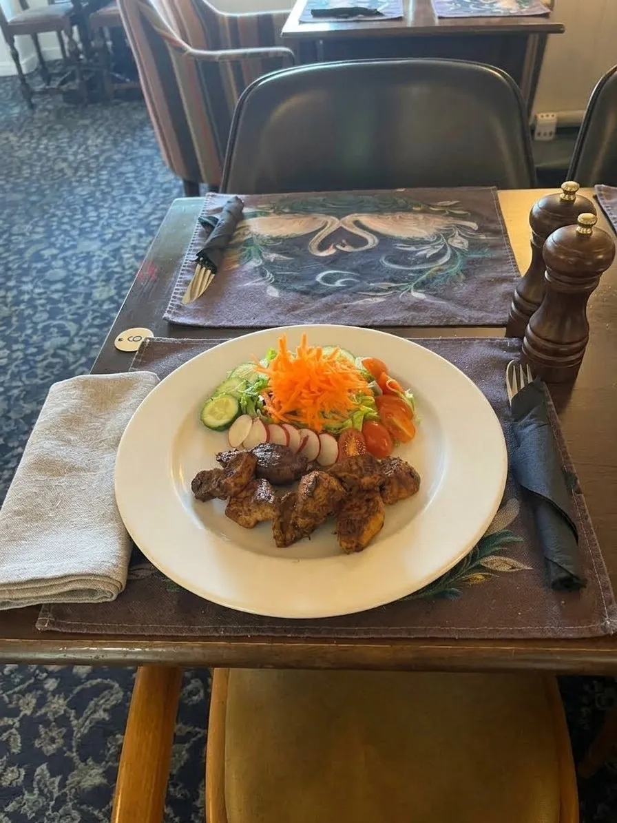 Grilled chicken with a fresh salad, laid on a table in the dining room