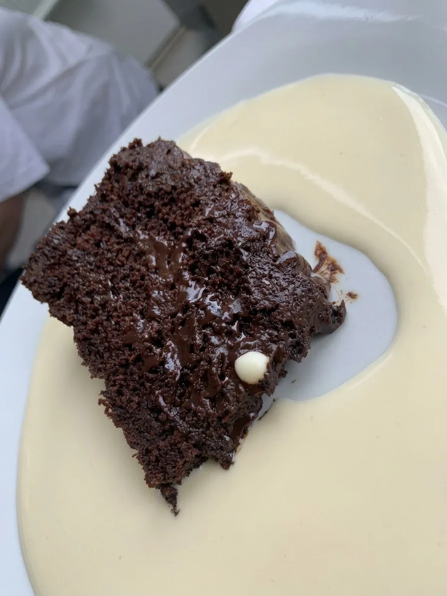 A slice of chocolate cake with custard