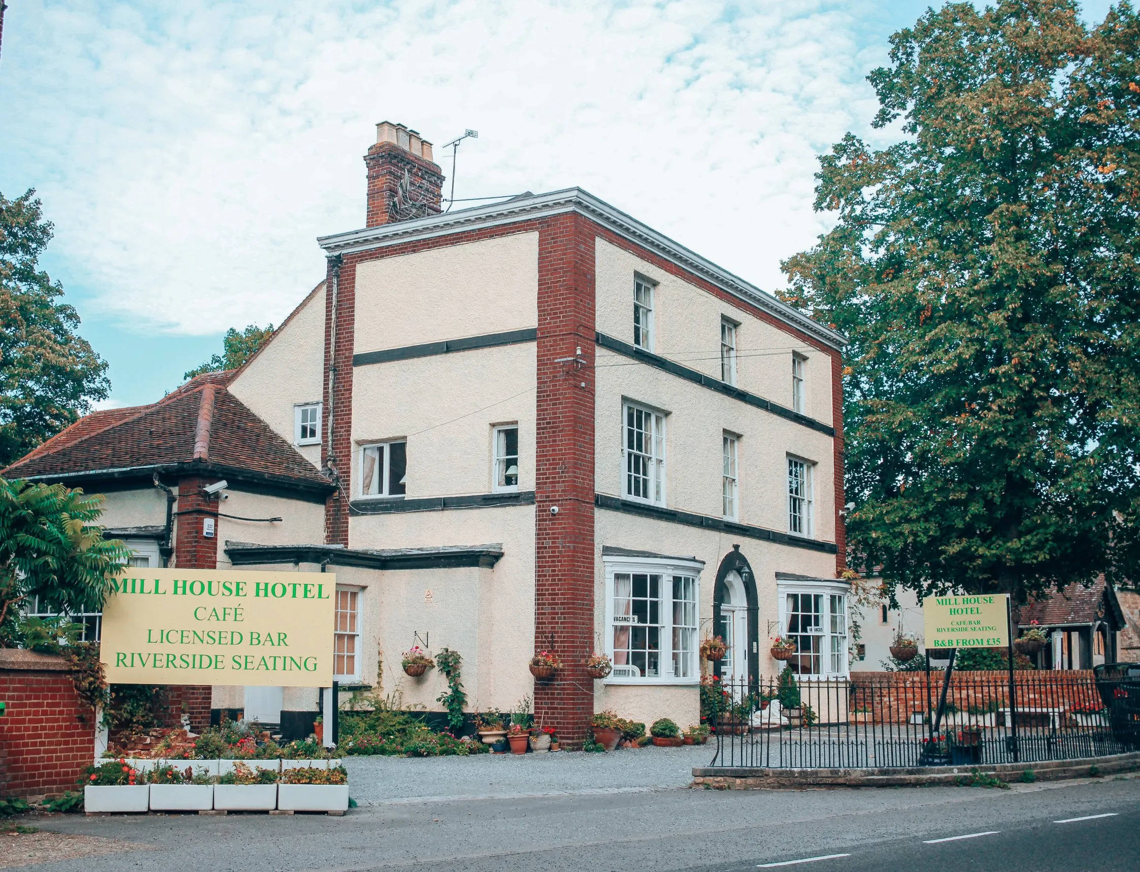 The Mill House Hotel's white Georgian front and green sign