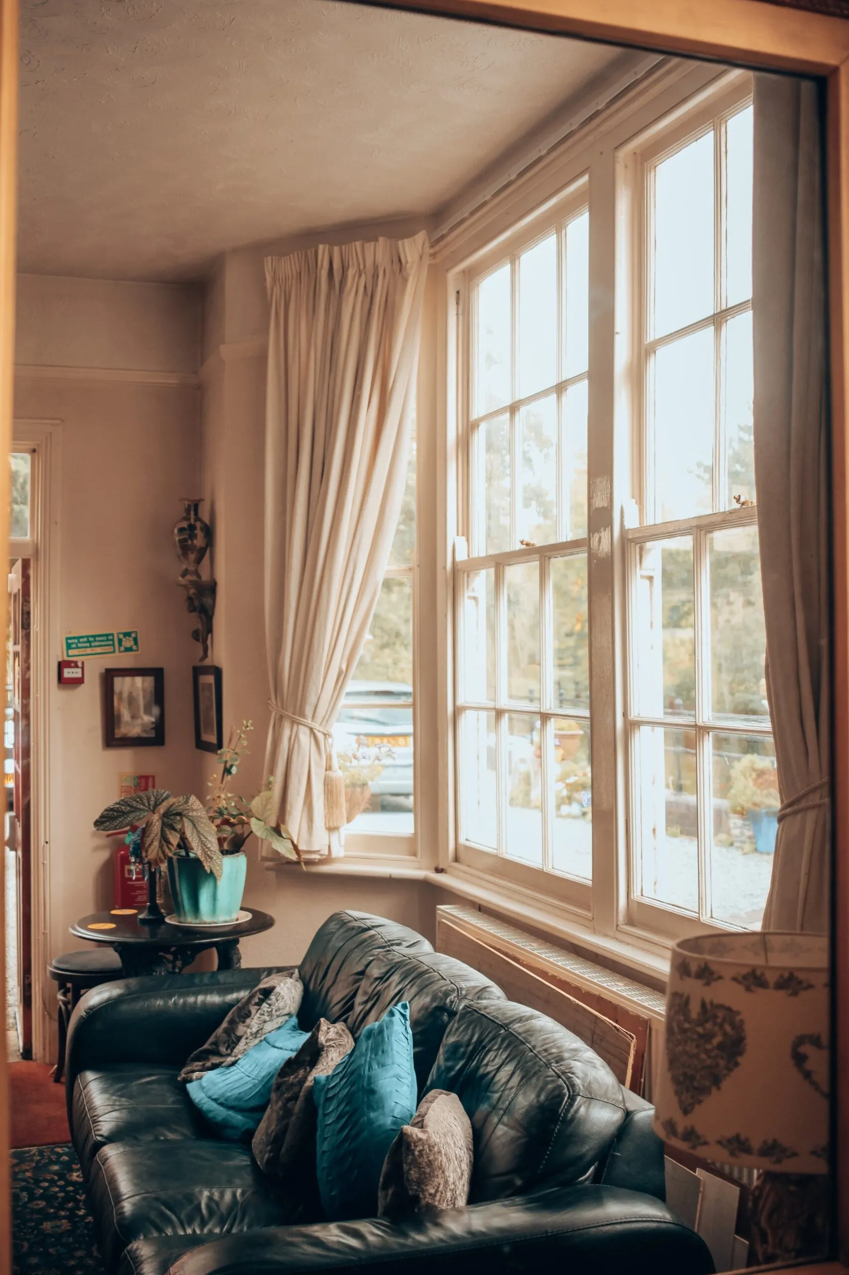 The guest lounge with a leather sofa beneath a tall window