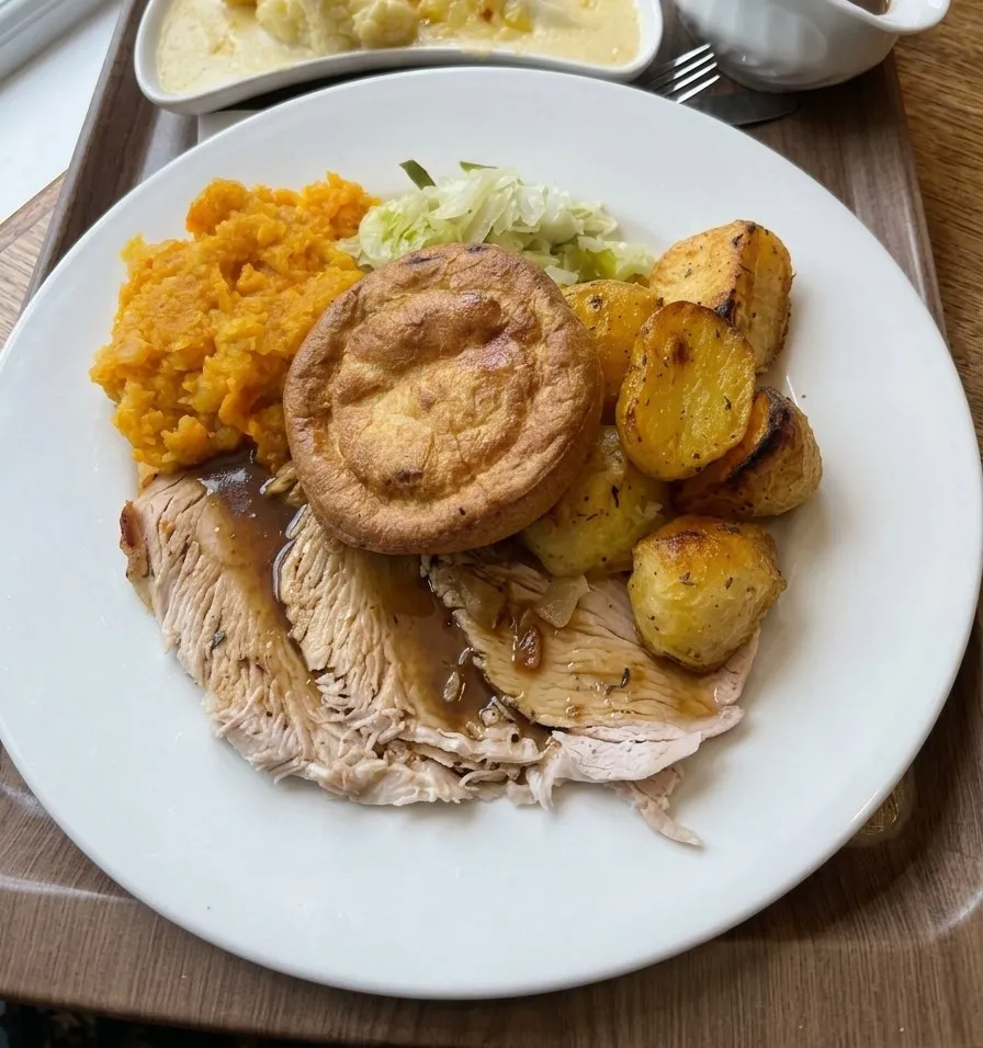Sliced roast with a Yorkshire pudding, mashed swede, cabbage and roast potatoes