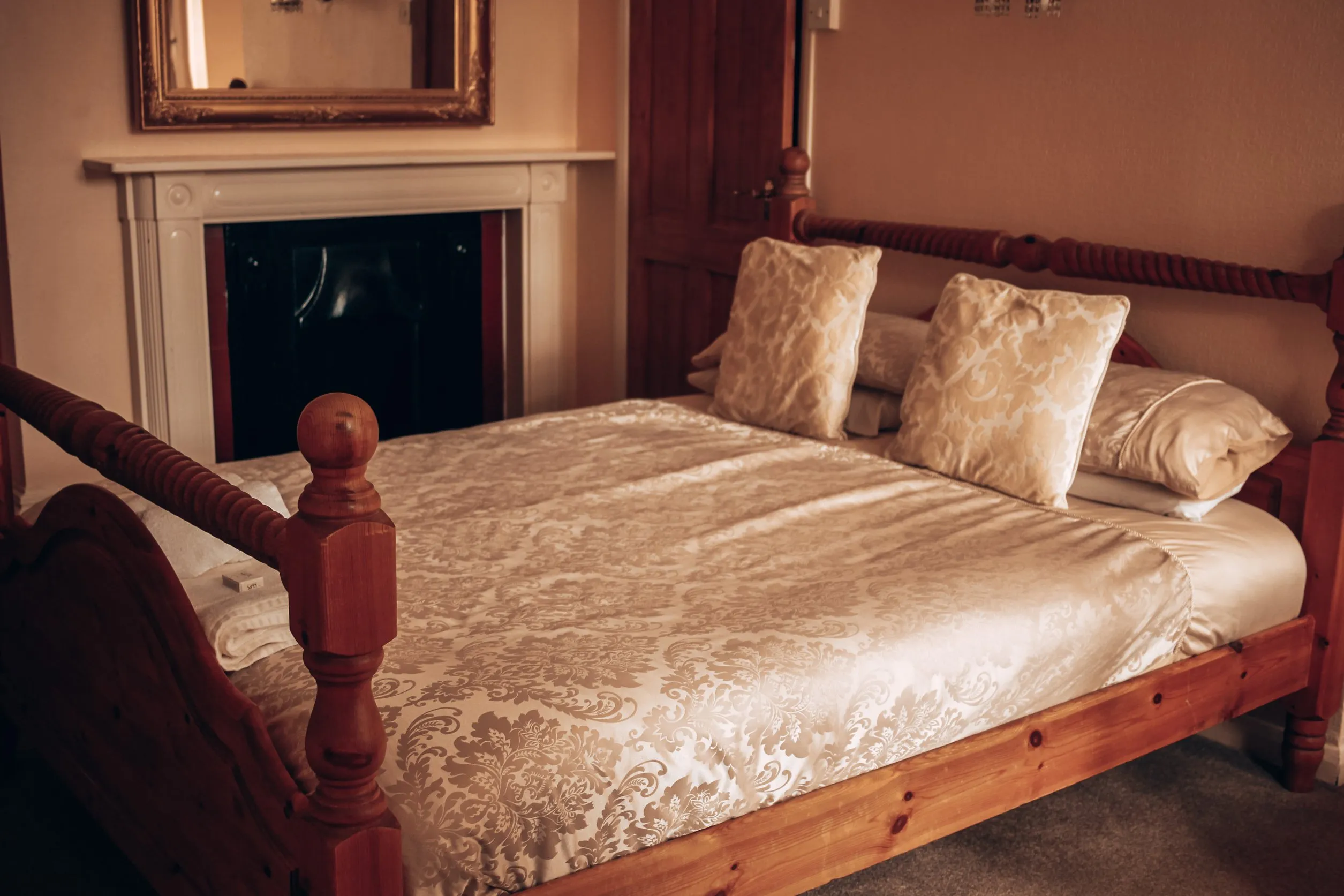 Double room with a carved wooden bed and fireplace