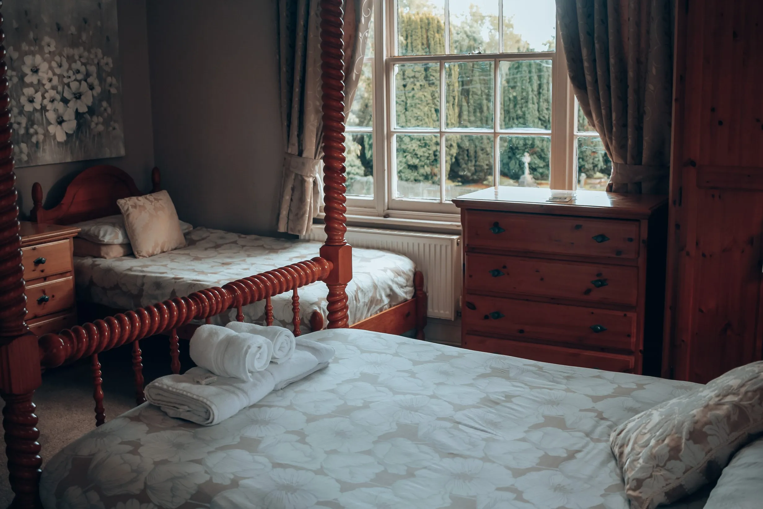Twin room with spindle beds under a large sash window